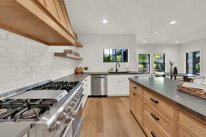 Kitchen with stainless steel appliances, tasteful backsplash, recessed lighting, open shelves, and light wood-style flooring