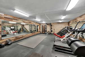 500 sq ft custom workout area featuring brick and reclaimed barn wood walls and mirrors
