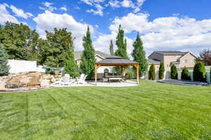 Fenced backyard featuring a gazebo and a patio