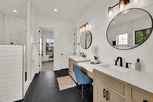 Master Bathroom featuring a walk in shower, two vanities, dark tile patterned flooring, and recessed lighting