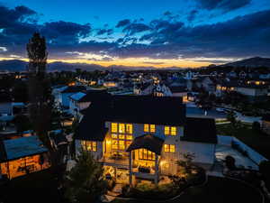 Back of property at dusk featuring a residential view, a mountain view, and a patio area