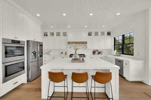 Kitchen featuring recessed lighting, a breakfast bar area, white cabinetry, appliances with stainless steel finishes, and wood ceiling
