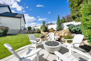 Fenced backyard featuring a fire pit and a patio
