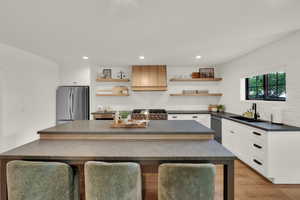 Kitchen with dark countertops, decorative backsplash, appliances with stainless steel finishes, a kitchen island, and recessed lighting