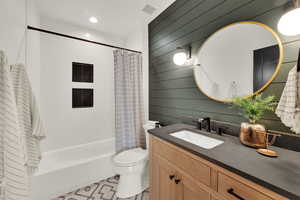 Master Suite Bathroom for MIL apartment with shower / bath combination with curtain, vanity, wood walls, and recessed lighting