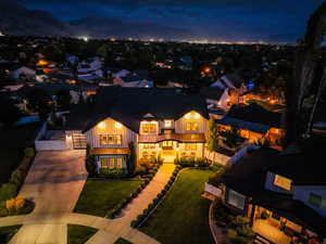 View of front of house featuring driveway, board and batten siding, and a balcony