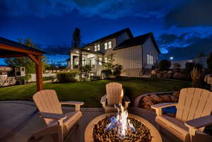 Patio at twilight featuring a yard, a patio area, an outdoor fire pit, and a gazebo