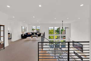 Loft area with staircase with recessed lighting and carpet floors