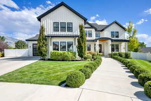 Modern inspired farmhouse with board and batten siding, a standing seam roof, and a metal roof