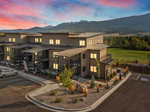 View of front of property with a standing seam roof, a metal roof, a mountain view, and uncovered parking
