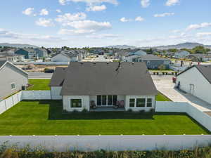 View of front of home featuring a shingled roof, a residential view, a fenced backyard, and a mountain view