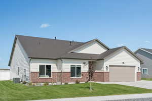 View of front facade with board and batten siding, brick siding, and a front yard