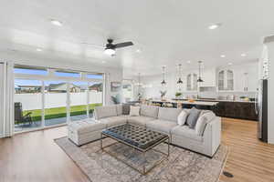 Living area with a ceiling fan, light wood-type flooring, recessed lighting, and a textured ceiling