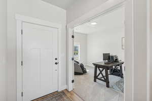 Foyer featuring light wood finished floors and baseboards