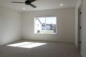Carpeted empty room with ceiling fan and recessed lighting