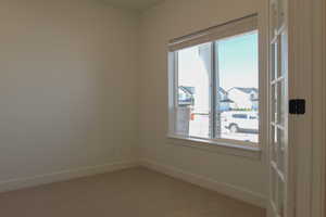 Empty room with baseboards and carpet