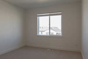 Empty room featuring baseboards and carpet