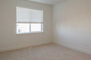 Unfurnished room featuring light carpet and baseboards