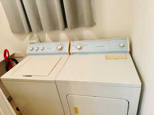 Laundry room with a textured wall and washer and clothes dryer