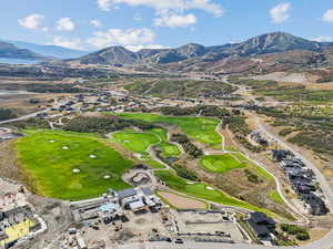 Aerial view of property's location featuring a mountainous background and a local golf course