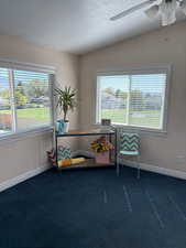Sitting room with a textured ceiling, ceiling fan, dark colored carpet, and vaulted ceiling