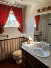 Bathroom featuring a textured wall, washtub / shower combination, and vanity