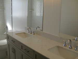 Full bath with double vanity and shower / bath combination