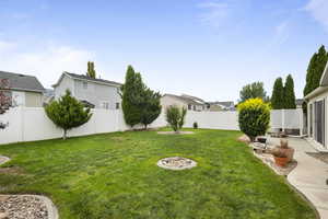 Fenced backyard with a patio area and an outdoor fire pit
