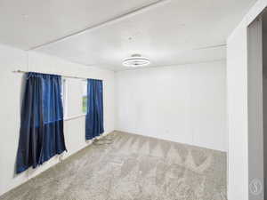 Empty room with carpet floors and a textured ceiling