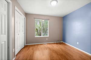 Unfurnished bedroom featuring wood finished floors and a closet