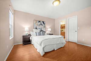 Bedroom featuring wood finished floors and ensuite bath