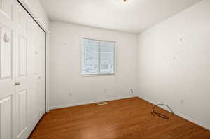 Unfurnished bedroom featuring wood finished floors and a closet