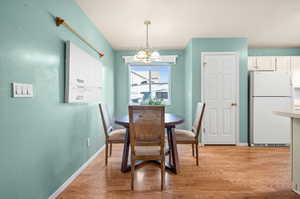 Dining area featuring a chandelier and light wood finished floors