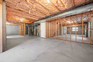 Unfinished basement with heating unit and water heater