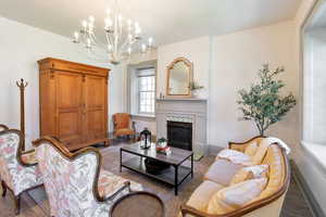 Living room featuring wood finished floors, a premium fireplace, and a chandelier