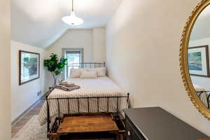 Bedroom featuring lofted ceiling and wood finished floors