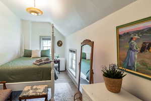 Bedroom with vaulted ceiling and wood finished floors