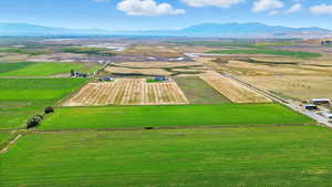 Aerial view of sparsely populated area featuring a mountain backdrop and extensive farmland