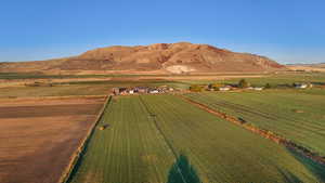 Aerial view of sparsely populated area with a mountain backdrop and farmland