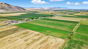 Aerial view of sparsely populated area with a mountainous background and rows of crops