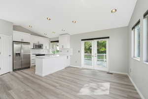 Kitchen featuring stainless steel appliances, recessed lighting, backsplash, white cabinets, and french doors