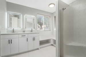 Full bath with a stall shower and double vanity