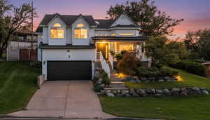 View of front of home with a front yard, driveway, and covered porch