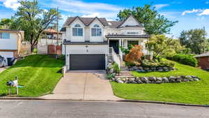 View of front of house with a front lawn, a garage, and concrete driveway