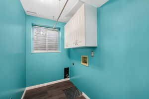 Laundry area with cabinet space, dark wood-style flooring, washer hookup, electric dryer hookup, and a textured ceiling
