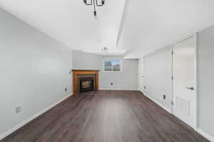 Unfurnished living room featuring dark wood finished floors and a fireplace