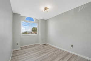 Spare room with light wood-type flooring and baseboards