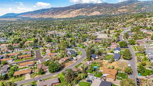 Aerial view of property and surrounding area with mountains and nearby suburban area