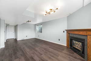 Unfurnished living room featuring a fireplace, dark wood-style floors, and a textured ceiling