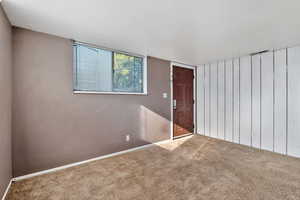 Carpeted spare room featuring baseboards
